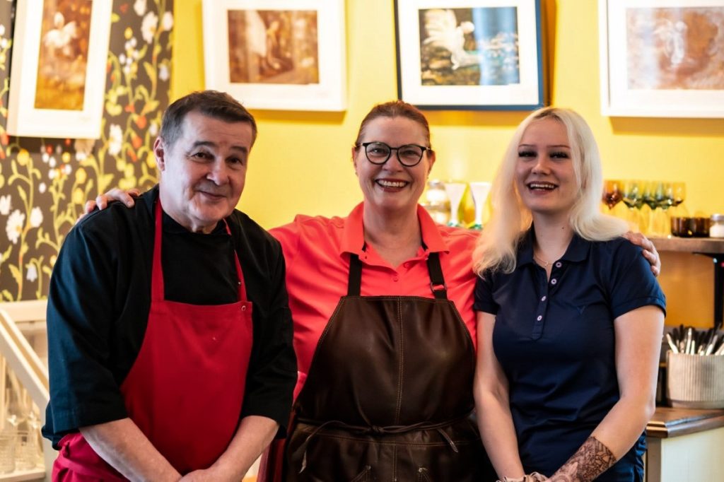 Eva Johansson (i mitten) driver restaurangen Matmalmen i Pargas. Hon säger att företagsandan i staden har stärkts under de senaste tre åren. Till vänster Hannu Leppänen och till höger Amanda Laurén.